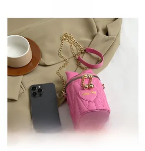 Close-up of pink quilted bucket bag with chain strap compared to a smartphone