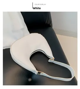 Détail du sac bandoulière en PU blanc mat avec boucle en métal doré sur fond noir sombre