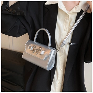 Silver bow accent crossbody bag shown on model with minimalist high-fashion styling