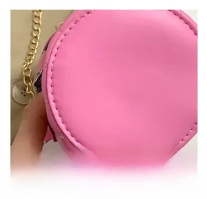 Macro detail showing precise stitching on a pink leather chain bag with golden chain