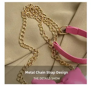 Detail of elegant gold chain hardware and pink leather bow on a stylish handbag strap