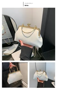 Close-up of white vintage evening bag with golden metal frame and floral texture