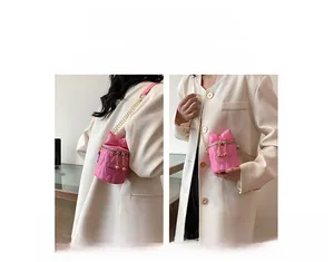 Detailed view of pink mini bucket bag with quilted heart pattern and bow decoration