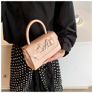Detailed shot of a pink patent leather mini handbag with a silver butterfly clasp