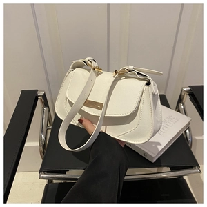 Close-up of beige lychee leather underarm bag with gold hardware and flap closure