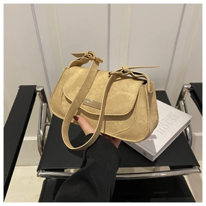 Detail of beige canvas underarm bag with gold metal buckle and adjustable strap