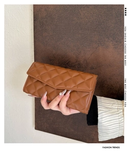 Detailed view of brown quilted envelope clutch bag with leather texture and flap closure