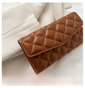 Macro detail of brown quilted faux leather wallet featuring a classic lattice stitch pattern