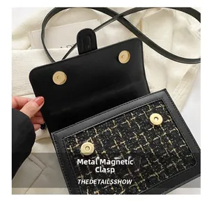 Detailsicht der magnetischen Hardware-Verschlüsse an einer schwarzen Tweed-Umhängetasche