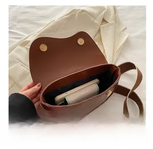 Vue intérieure du sac selle marron montrant la capacité pour smartphone et petit portefeuille