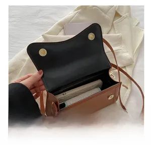 Detail showing the internal storage capacity of the brown crossbody flap bag with magnetic snap