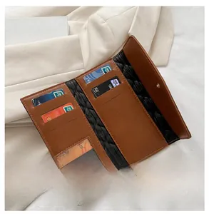 Detail view of brown quilted wallet interior with card slots and transparent ID window