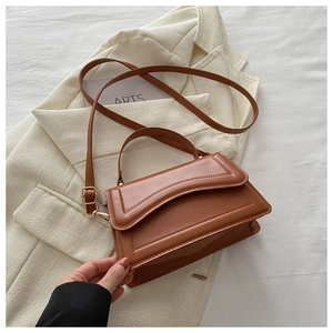 Detail of caramel leather shoulder bag with fine stitching on an artistic background