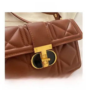 Macro detail of brown quilted leather texture with luxury gold T-shaped twist lock