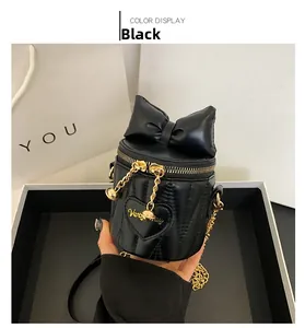 Detail of black quilted bucket bag with large leather bow and heart stitching design