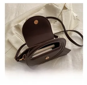 Macro view of dark brown crossbody bag showing internal capacity for phone and card holder