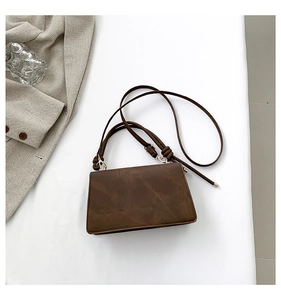 Dettaglio della borsa a tracolla opaca marrone scuro con texture liscia e cuciture