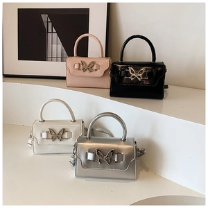 Close-up of stylish mini handbags with metallic bow buckles in pink, white and silver