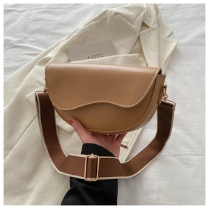 Détail du sac selle vintage avec rabat ondulé et lettrage doré de mode élégant