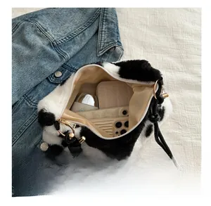 Internal storage view of cow print plush shoulder bag with phone and cosmetics
