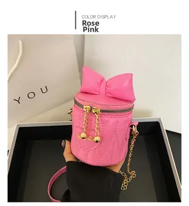 Detail of rose pink heart-quilted bucket bag with 3D bow and gold chain strap