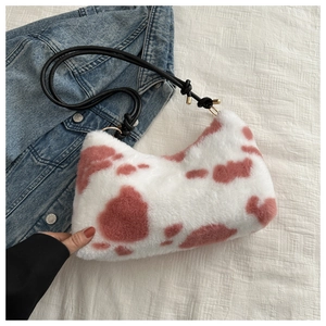 Detailed view of plush cow print shoulder bag with soft faux fur and leather strap