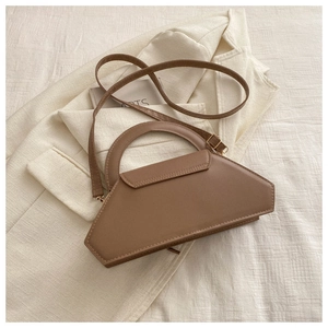 Macro detail of a brown geometric leather crossbody bag with hard handle and shoulder strap