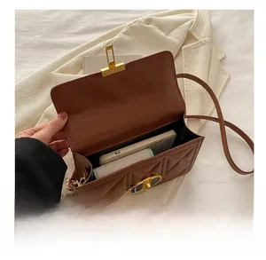 Detail of interior capacity showing a brown quilted crossbody bag with golden hardware