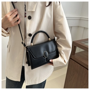 Détail d'un sac en cuir PU noir avec boucle métallique dorée et coutures de précision
