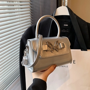Chic silver handbag with a metallic bow buckle and adjustable strap for women