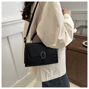 Vue latérale d'un sac bandoulière en cuir PU noir avec boucle dorée sur un mannequin femme