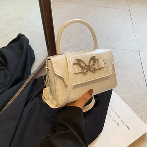 Chic cream bow knot handbag with metallic clasp and adjustable shoulder strap