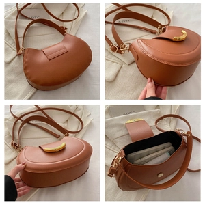 Detail view of brown moon saddle bag showing golden hardware and adjustable straps