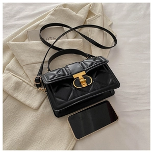 Detail of black quilted mini bag with gold T-lock shown next to a smartphone