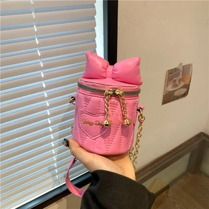 Pink quilted bucket bag with large bow and gold chain strap in a sweet girl style