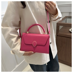 Sac bandoulière en PU rose fuchsia avec fermoir doré porté par un mannequin en trench