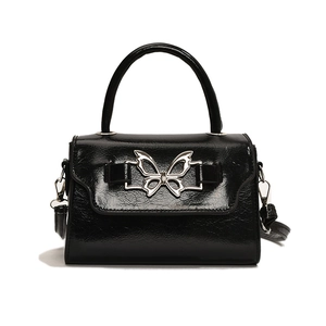 Elegant black faux leather handbag with a large silver butterfly metal buckle closure