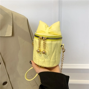 Chic yellow mini cylinder bucket bag with bow detail and quilted heart patterns
