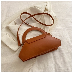 Detailed top view of a brown geometric leather handbag on a minimalist cream fabric background
