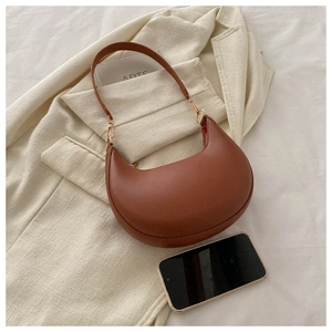 Detail of a brown PU leather half-moon shoulder bag with sleek stitching and metal buckle