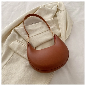 Detailed view of caramel brown PU leather half-moon bag with gold metal hardware