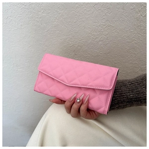 Detail of pink quilted leather envelope wallet with classic diamond stitching and flap