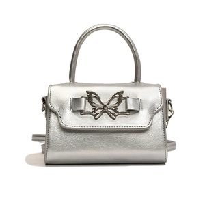 Silver metallic crossbody bag with butterfly buckle and top handle in y2k style