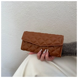 Handheld view of a brown quilted long wallet with a classic diamond lattice pattern