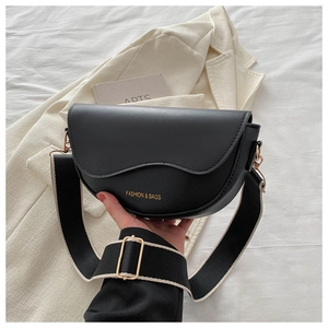 Détail d'un sac demi-lune noir en cuir PU avec large bandoulière en toile bicolore