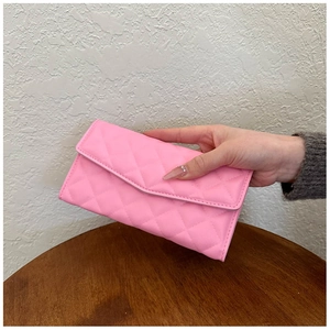 Close-up of bright pink quilted faux leather envelope clutch with meticulous stitching