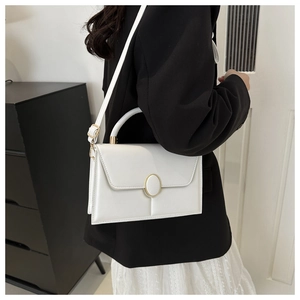 Détail du sac carré en cuir PU blanc avec boucle dorée et poignée supérieure élégante