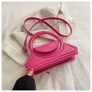 Detail of fuchsia geometric handbag with large round handle and adjustable shoulder strap