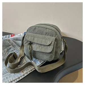 Detail of army green corduroy shoulder bag showing texture and adjustable woven strap
