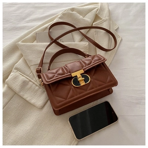 Detail of brown quilted faux leather bag with black and gold T-shaped metal lock and phone
